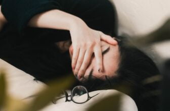 woman in black long sleeve shirt covering her face