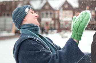 woman in black coat and green knit scarf