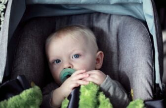 baby on gray stroller