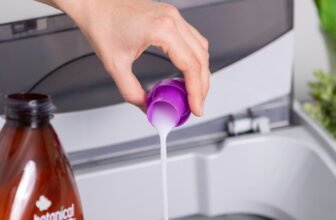 person holding purple plastic bottle